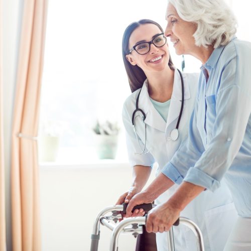 Professional one. Cropped image of young doctor helping senior woman with walking frame